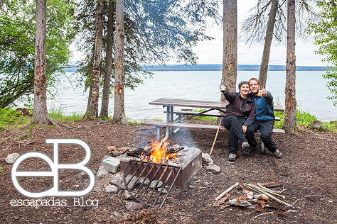 Una cervecita frente al fuego en la orilla de un lago.